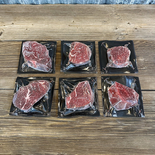 Six filet mignon steaks, two each at 6, 8 and 10 oz, on a wood table