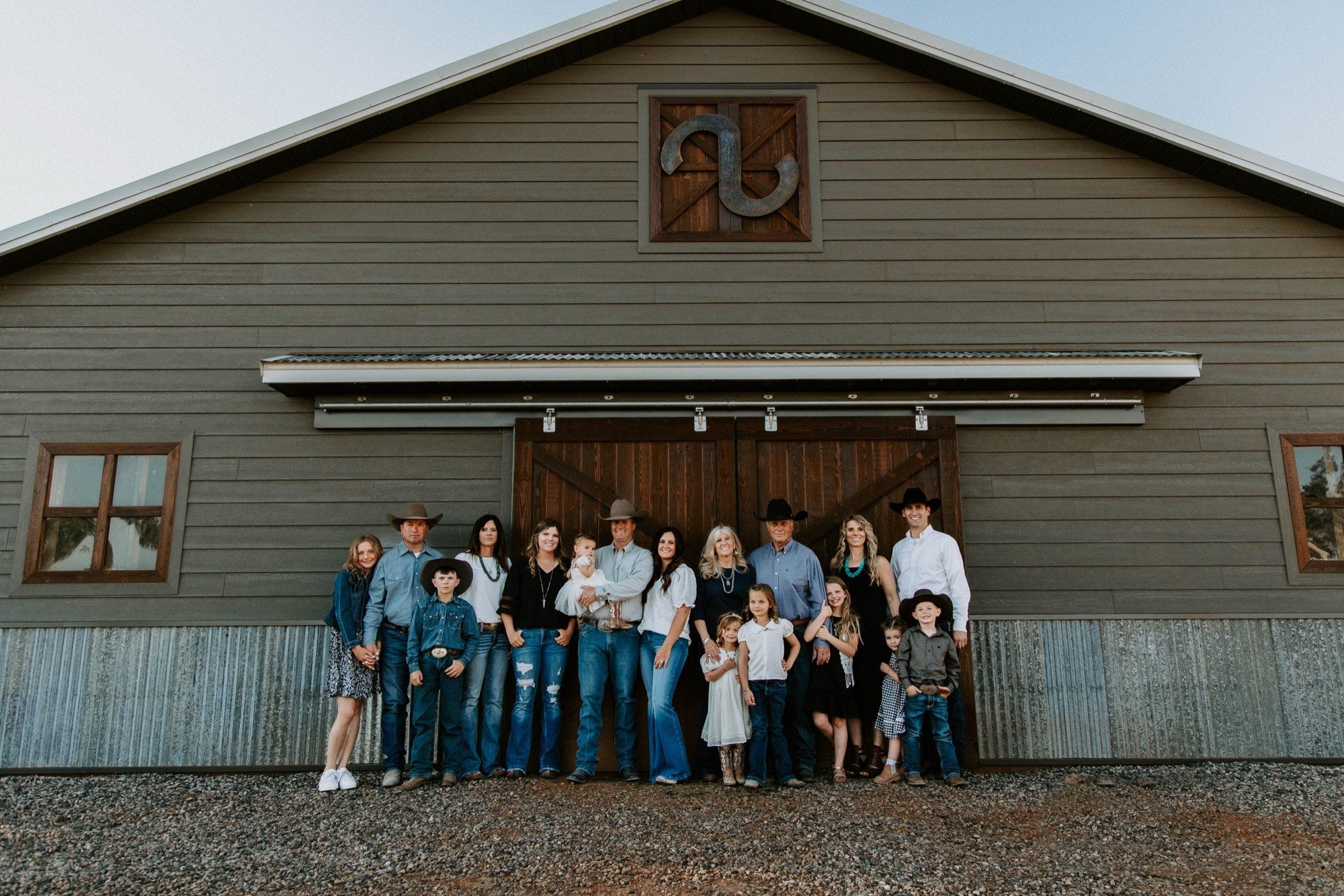 The whole Scott family in front of the S Ranch barn, the S Ranch brand on the gable