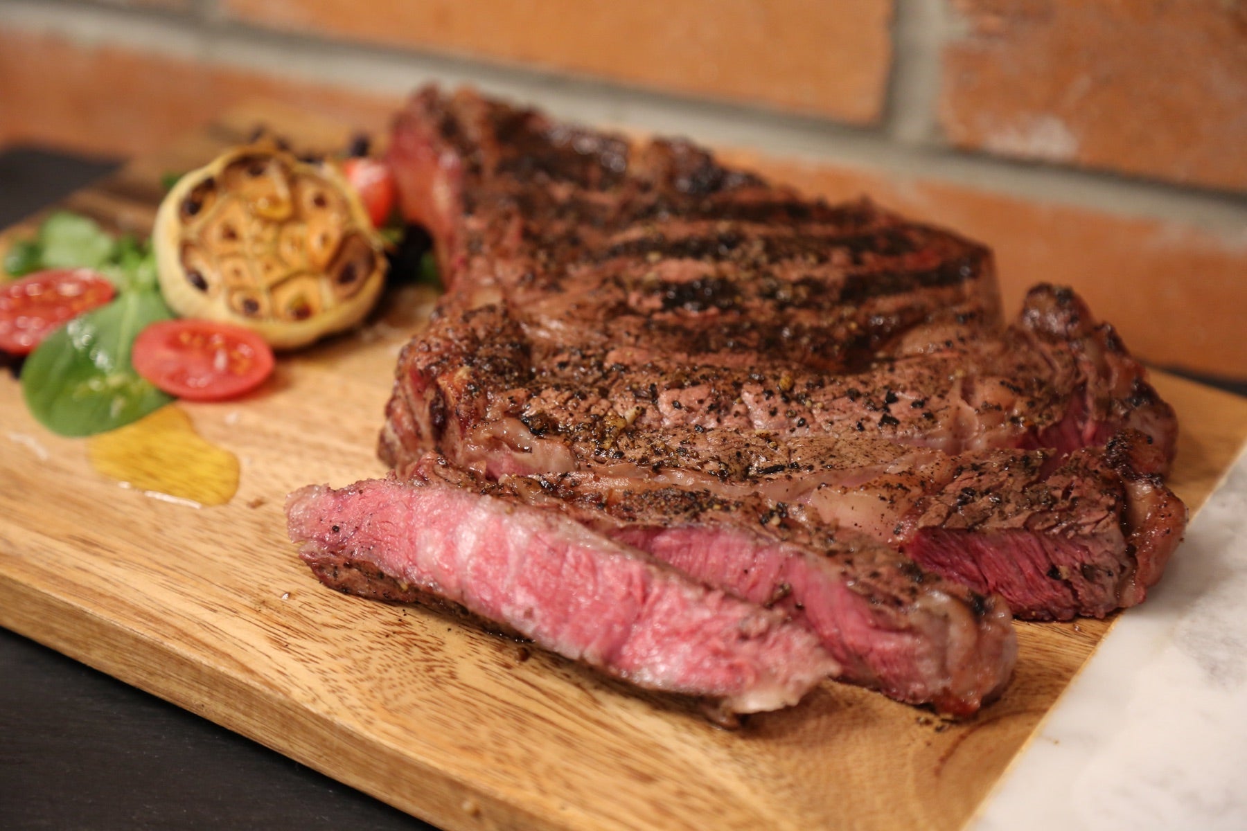Grilled ribeye, sliced, on a cutting board
